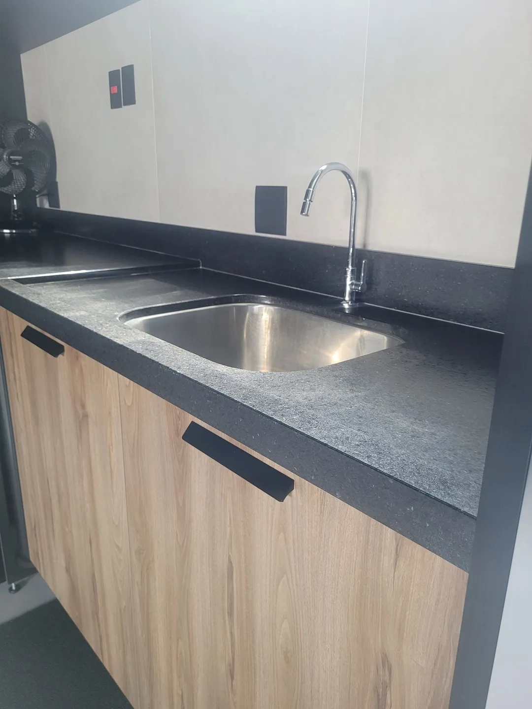 Bancada de área de serviço em granito Preto São Gabriel escovado com cuba de inox embutida, executada pela Mister Marmoraria em São Paulo