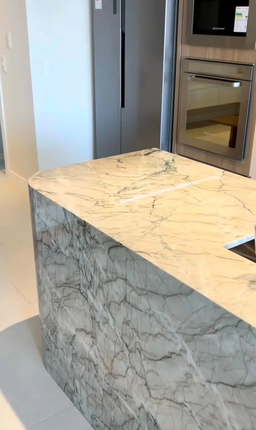 Ilha de cozinha em quartzito Vancouver com fechamento lateral em cascata e veios marcantes