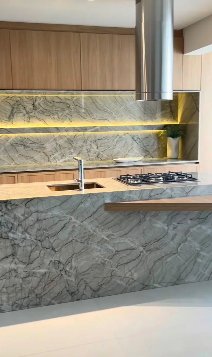 Ilha de cozinha em quartzito Vancouver com cuba de embutir, cooktop e rodabanca na mesma pedra
