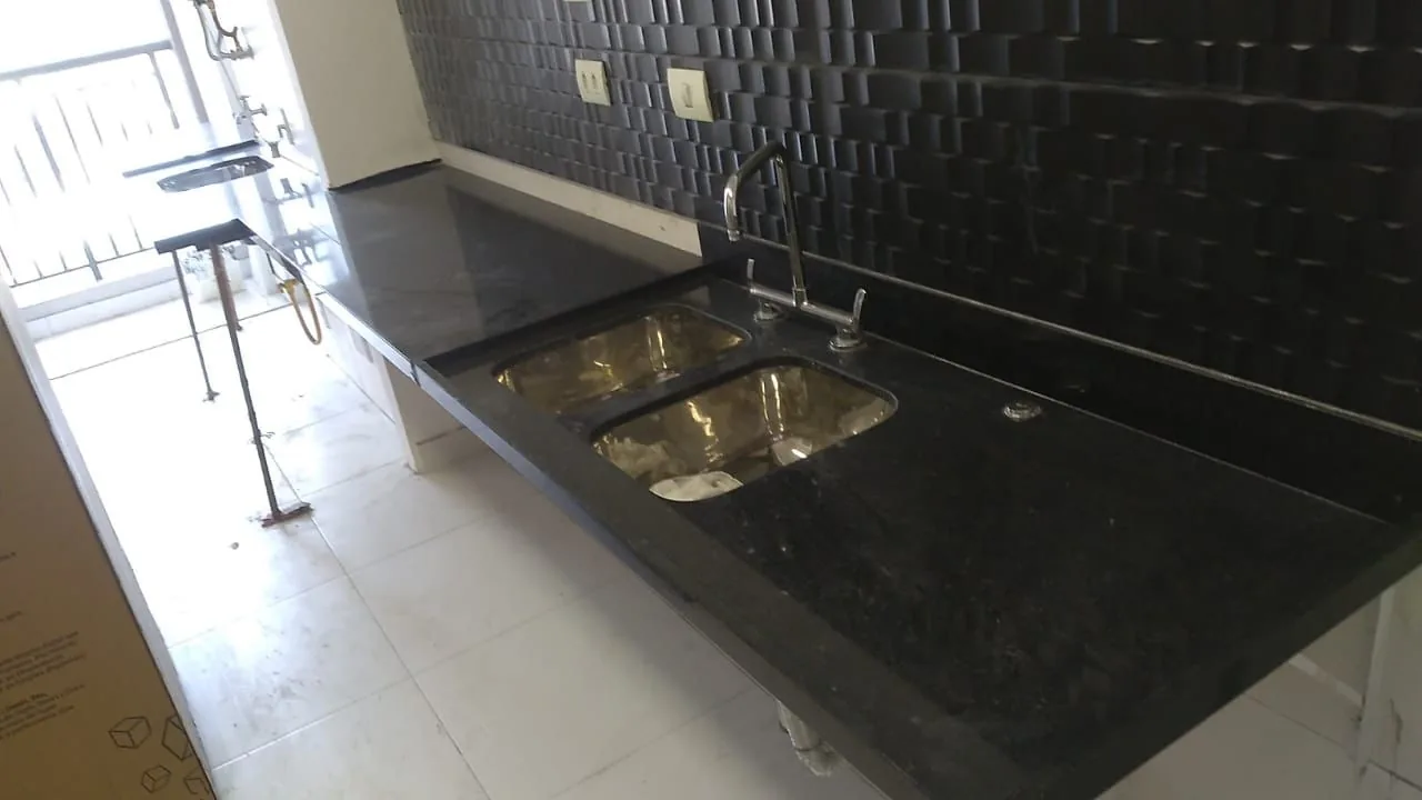 Bancada de cozinha em granito preto com duas cubas de inox e escorredor esculpido