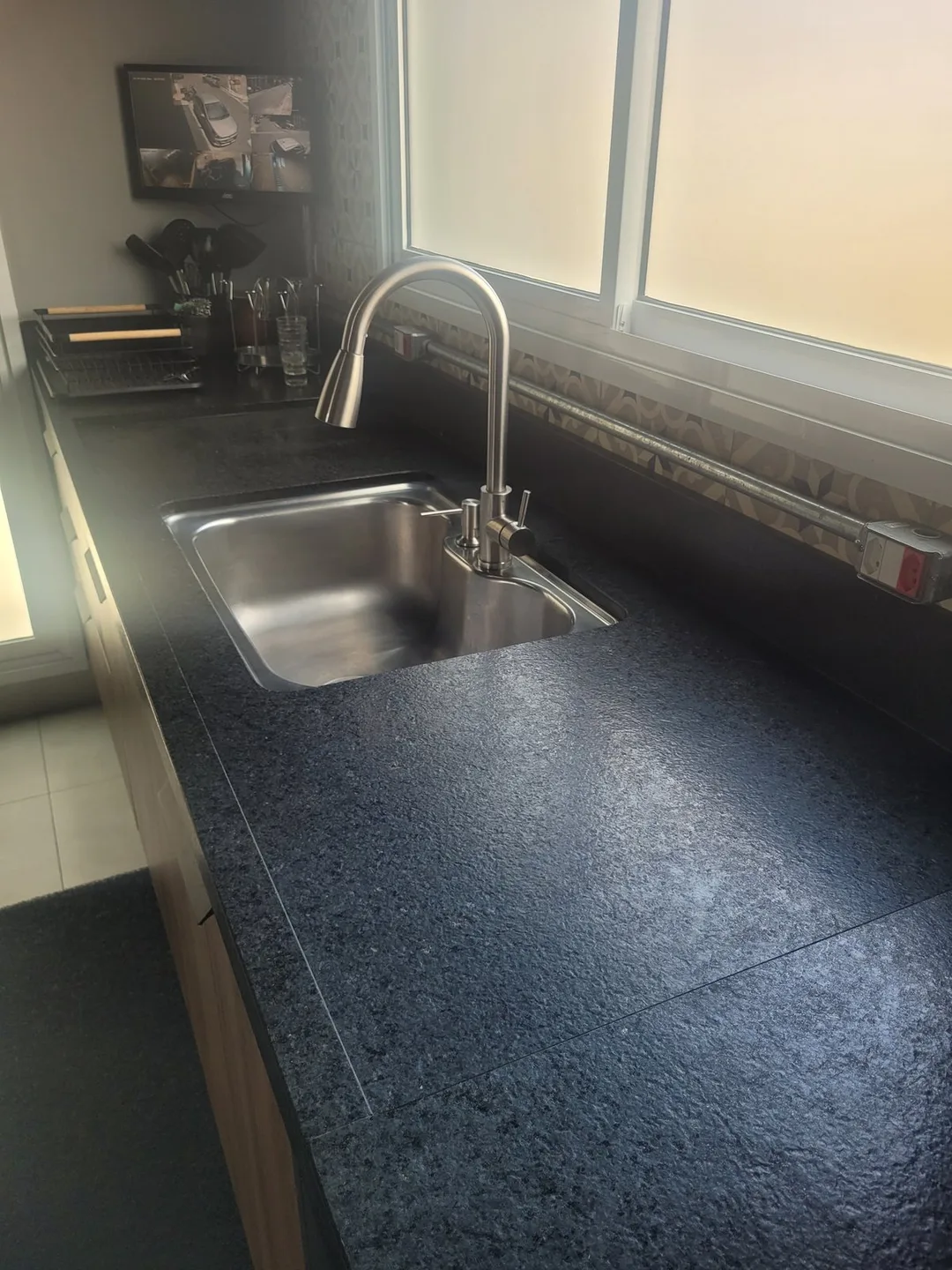 Bancada de cozinha em granito Preto São Gabriel escovado com cuba dupla de inox, executada pela Mister Marmoraria em São Paulo