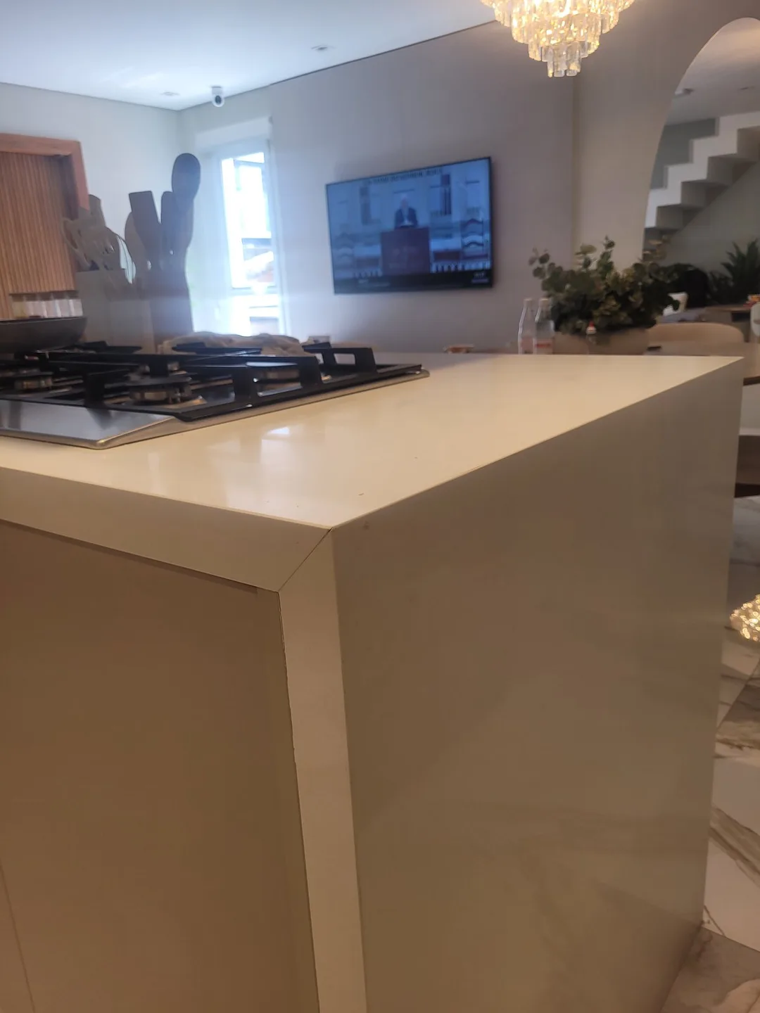 Ilha de cozinha em quartzo branco com cooktop e fechamento lateral, executada pela Mister Marmoraria em São Paulo